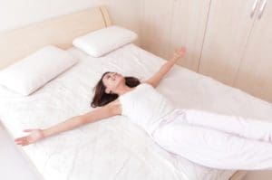 Happy woman lie down on her bed